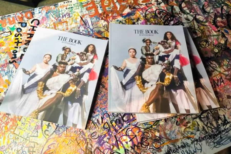 A few copies of the book are on a graffiti table, with four diverse models on the front page.