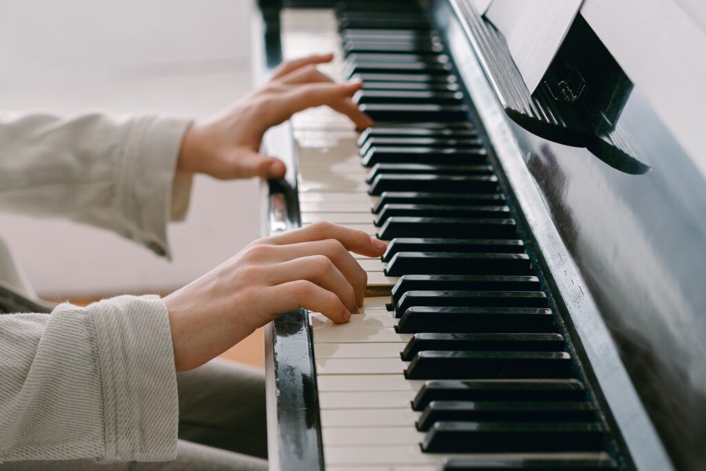Hands shown pressing down piano keys. 